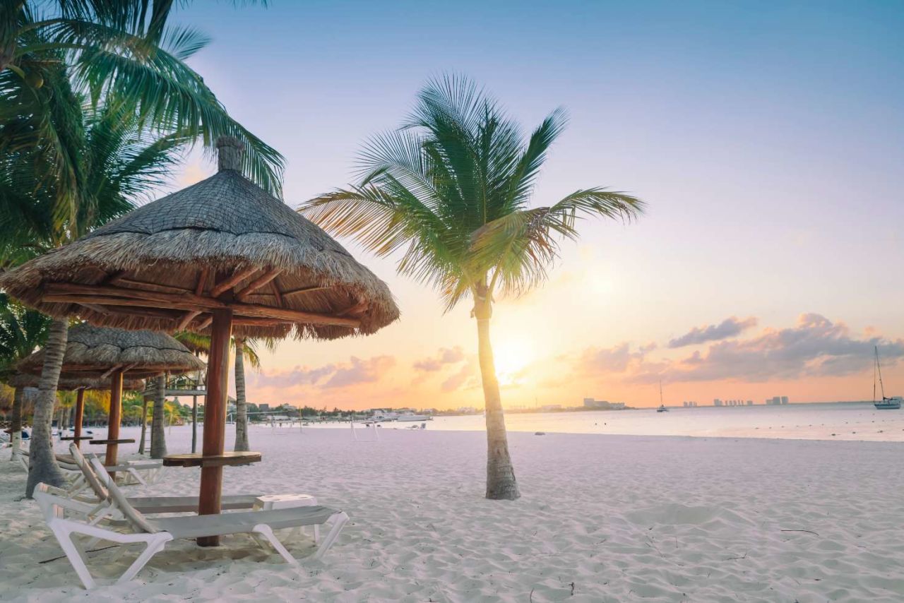 Palmiers sur une plage blanche avec coucher de soleil dans un complexe all inclusive